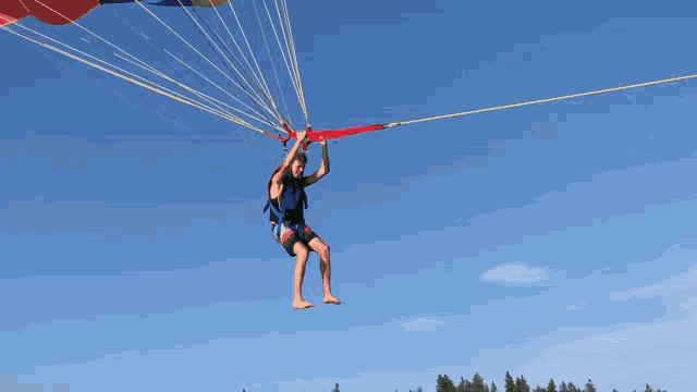 a man is flying through the air with a parachute