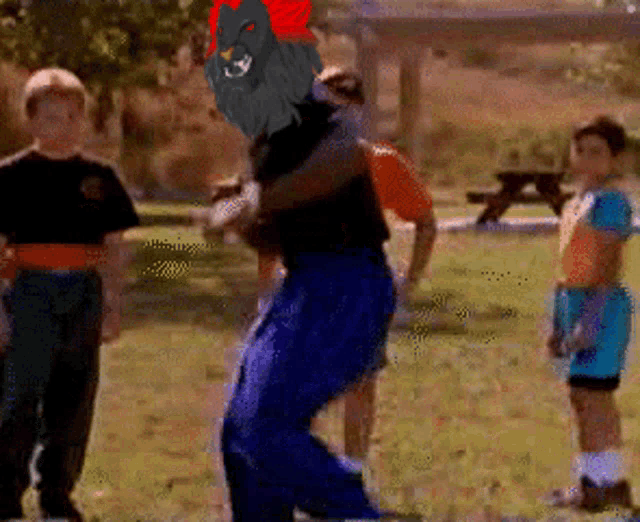 a group of boys are standing in a park with a cartoon character on their backs
