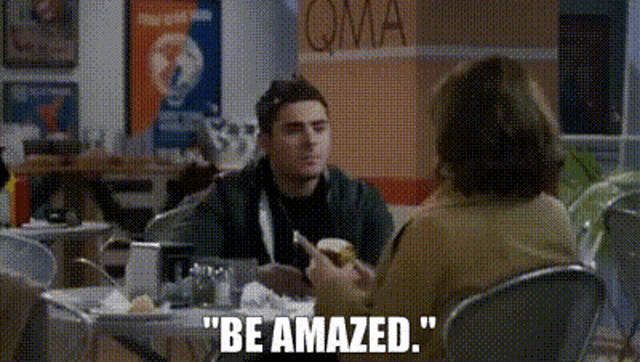 a man and a woman are sitting at a table in a restaurant and the man is talking to the woman .