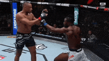 two men are fighting in a boxing ring and one of them is wearing a venum shorts