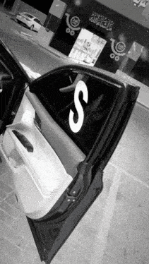 a black and white photo of a car with the letter s on it
