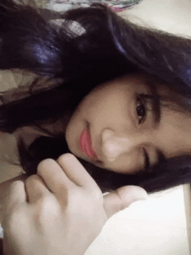 a close up of a woman 's face with a hand on her face