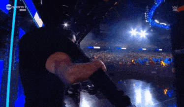 a man is standing in front of a crowd in a stadium .