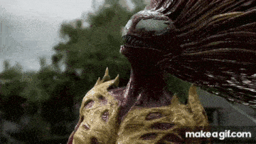 a statue of a monster with long hair is standing in the rain in front of a house .