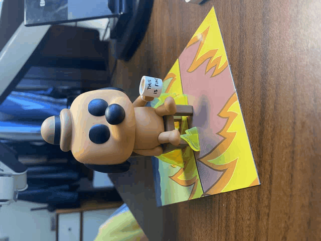 a funko pop figurine holding a sign that says this is fire