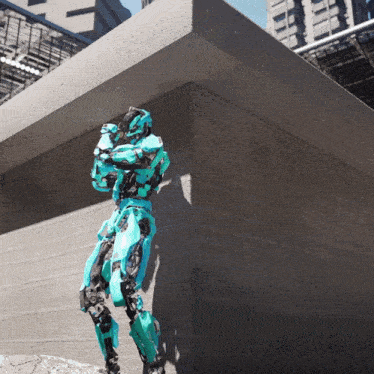 a robot in a blue suit is standing on a concrete wall