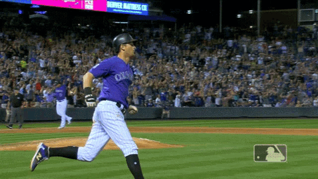 a baseball player wearing a purple uniform that says colorado