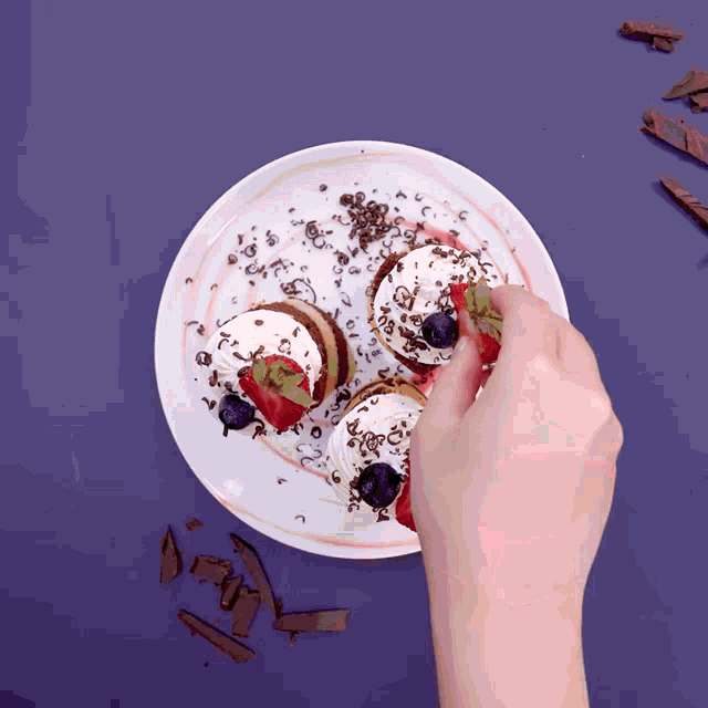 a plate of desserts with strawberries and blueberries on top