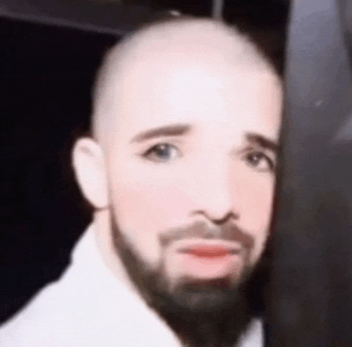 a bald man with a beard is wearing makeup and making a funny face .