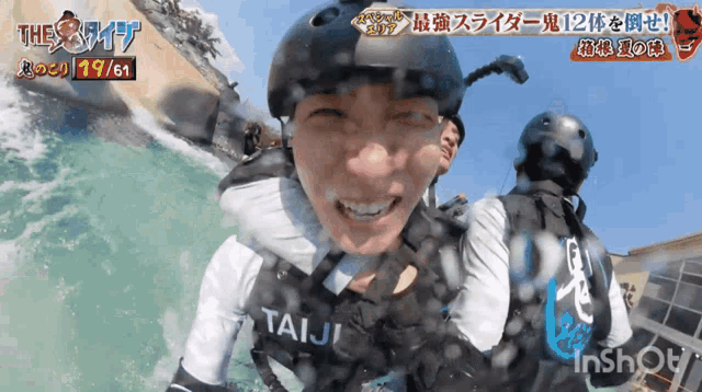 a person wearing a taiji helmet smiles while riding a water slide