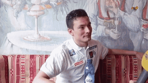 a man sitting on a couch with a bottle of isklar water