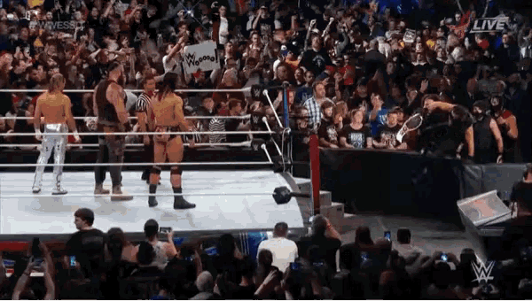 wrestlers in a wrestling ring with a sign that says superman on it