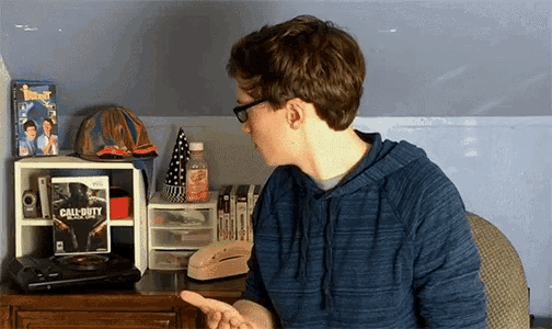 a young man sitting at a desk with a call of duty game on it