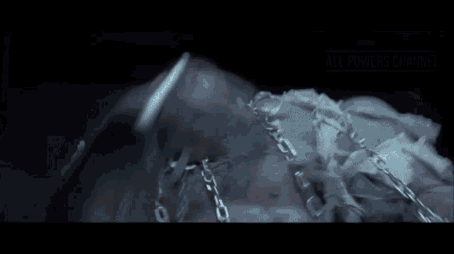 a man is chained to a pole in a dark room with the words " all power is channel " on the bottom right
