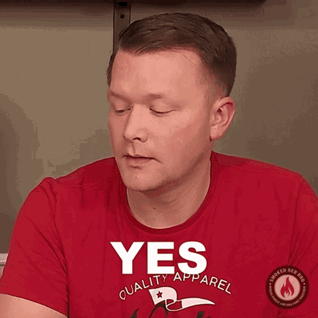 a man wearing a red shirt with the word yes on it