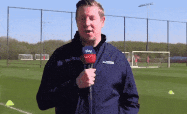 a man is holding a microphone that says sky sports