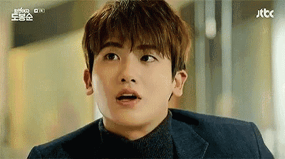 a close up of a man 's face with his mouth open and a surprised look on his face .