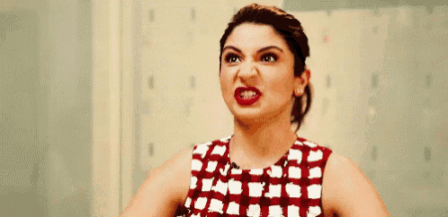a woman in a plaid dress is making a funny face .
