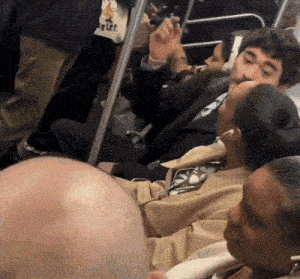 a group of people sitting on a train with a man wearing a shirt that says ' i love you '