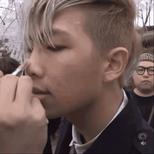 a close up of a person applying makeup to another person 's nose .
