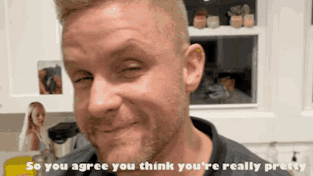 a man is making a funny face with the words so you agree you think you 're really pretty behind him