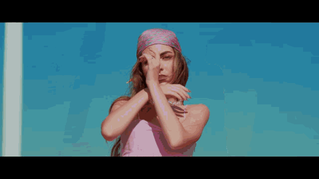 a woman in a pink dress is dancing with her arms outstretched