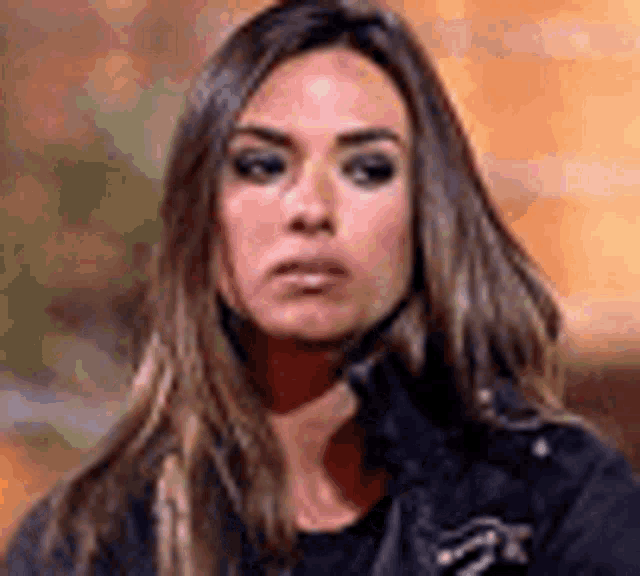 a woman with long hair is making a funny face while wearing a black jacket .