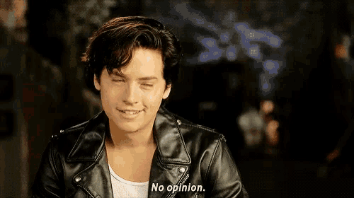 a young man in a leather jacket is smiling and says `` no opinion '' .
