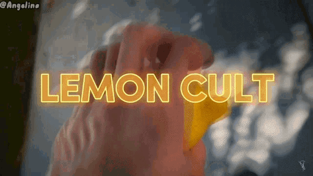 a person holding a yellow object with the words lemon cult written in neon