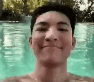 a young man is taking a selfie in a pool .