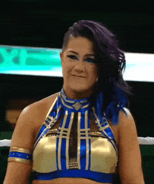 a woman with purple hair and blue eyes is wearing a gold and blue top