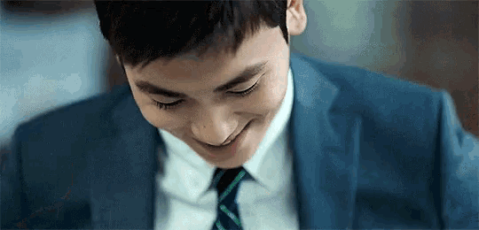 a man in a suit and tie is smiling .