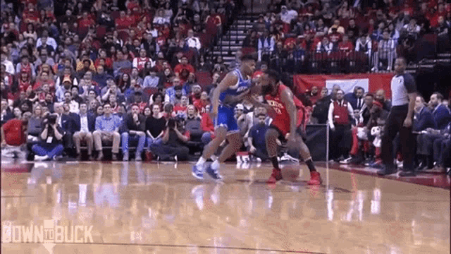 a basketball game is being played in front of a crowd of people