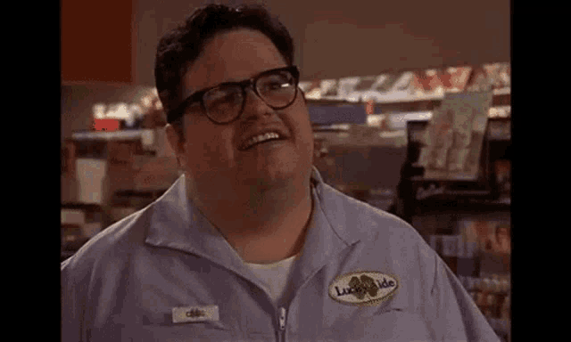 a man wearing glasses and a blue jacket is smiling .