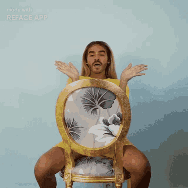 a man in a yellow shirt is sitting in a chair with a floral pattern