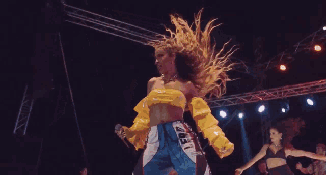 a group of women are dancing on a stage and one of them is wearing a shirt that says uefi