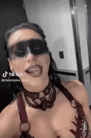 a woman with makeup on her face is taking a selfie in a hallway .