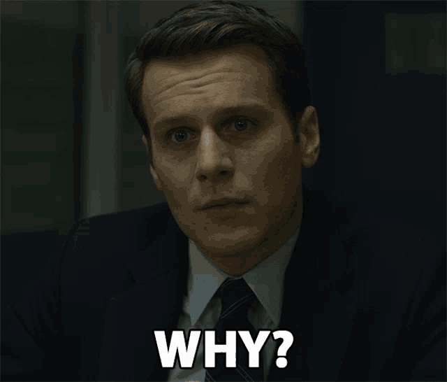 a man in a suit and tie asks the question why