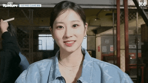 a woman wearing a blue denim jacket is smiling for the camera