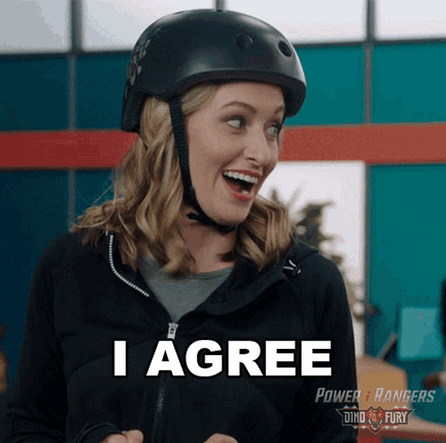 a woman wearing a helmet says " i agree " in front of a power rangers logo