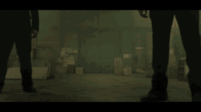 two men are standing next to each other in a dark room with smoke coming out of the walls .