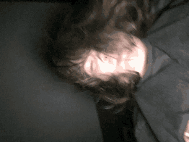 a blurry picture of a person 's face with a black shirt on