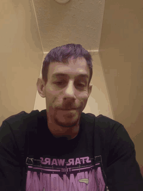 a man with purple hair is wearing a black shirt that says raw aatz