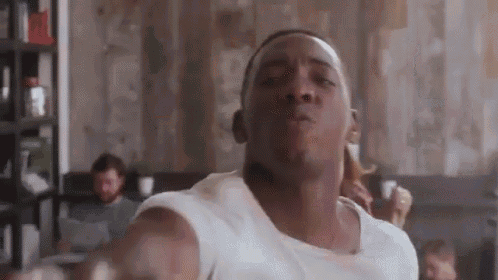 a man in a white shirt is making a funny face in a room .