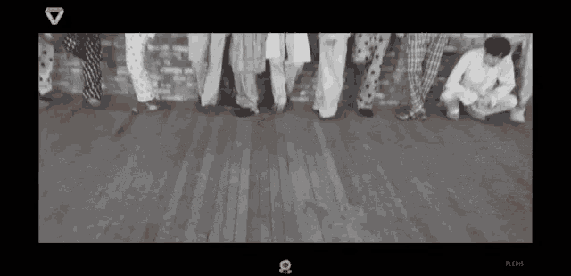 a group of people standing in a row on a wooden floor