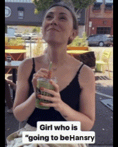 a woman in a black tank top is drinking a green smoothie ..