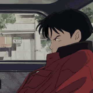 a man in a red jacket sits in the back seat of a car with a sign that says ' a ' on it