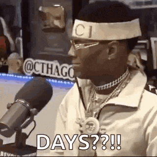 a man is sitting in front of a microphone wearing a headband that says gucci .