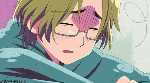 a boy with glasses is wrapped in a blanket and has a purple heart on his forehead .