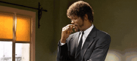 a man in a suit and tie smells his nose